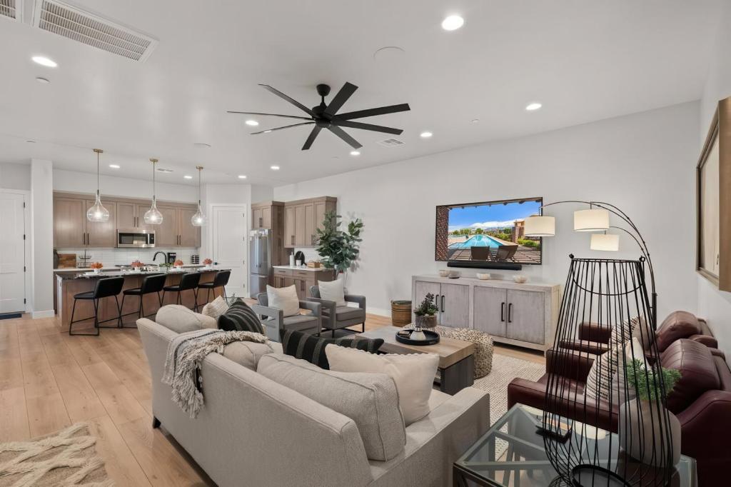 a living room with couches and a tv and a kitchen at Elim Gem w Pool BBQ Hot Tub N Sand Hollow in Hurricane