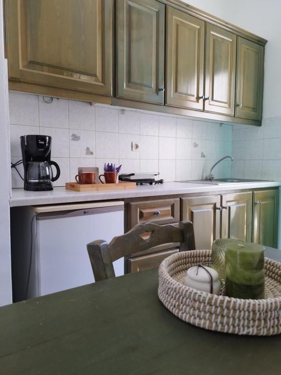 a kitchen with wooden cabinets and a table with a basket at Marathos in Kanakis