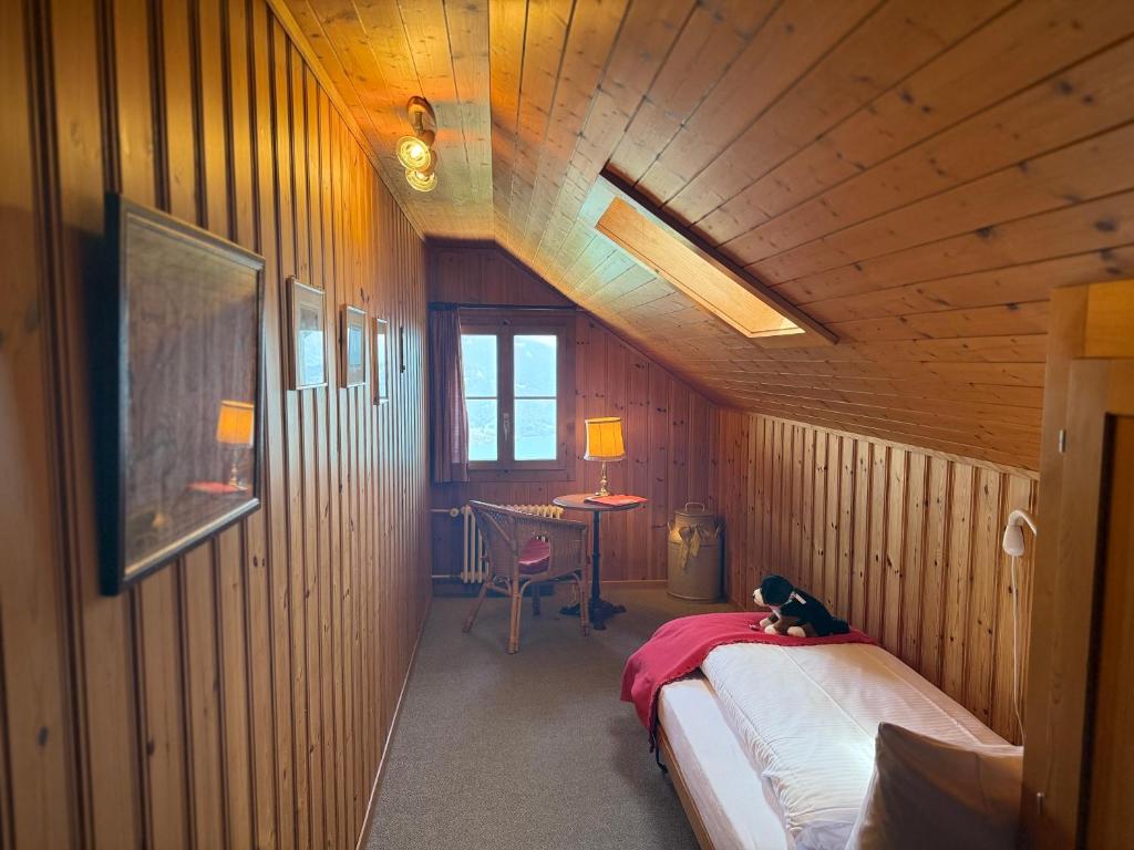 a bedroom with a bed and a desk in a room at Hotel Fassbind Beausite in Beatenberg