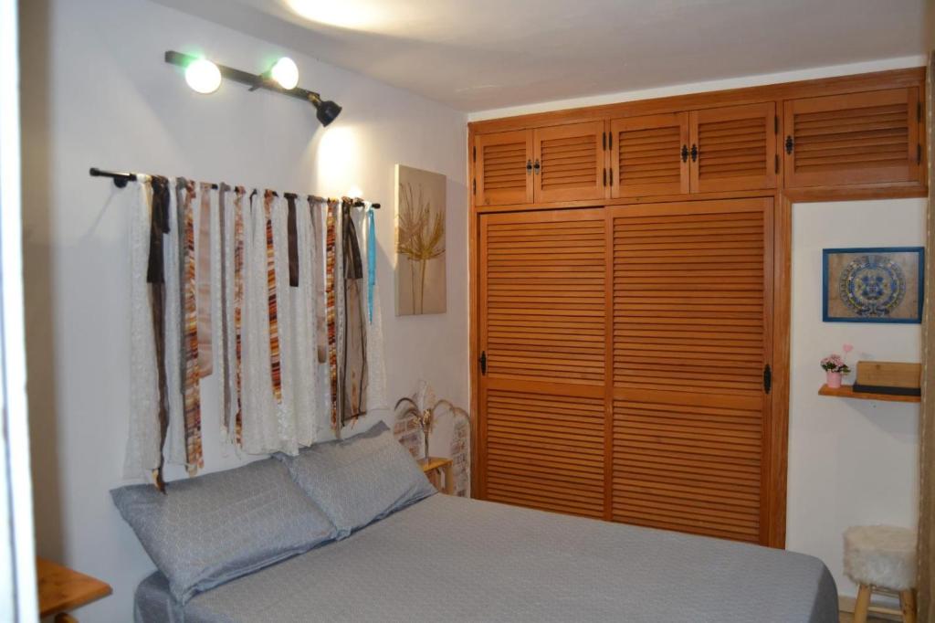 a bedroom with a bed and a wooden closet at La Casita Azul in Fuengirola