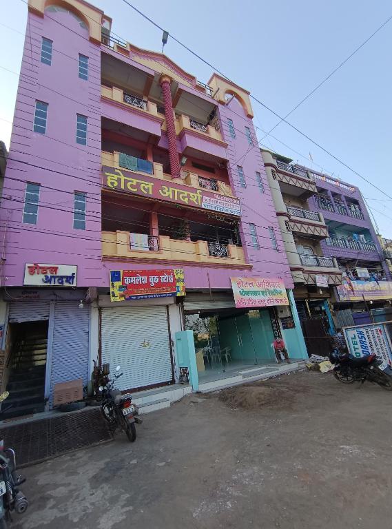 a pink building with motorcycles parked in front of it at hotel aadarsh in Sendhwa