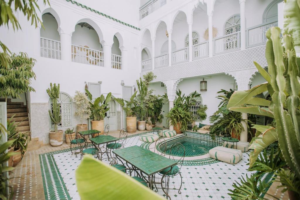 un patio interior con mesas y macetas en Riad Oriental Glory & Spa, en Marrakech