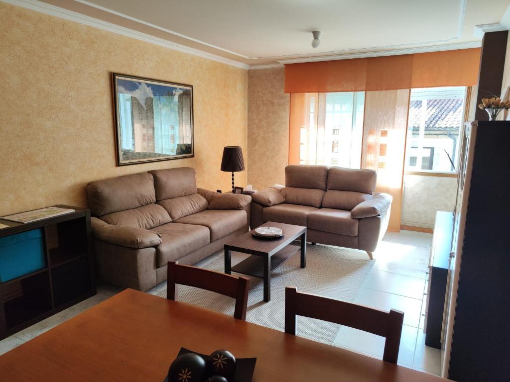 a living room with a couch and a table at Piso Pauser in Puentecesures