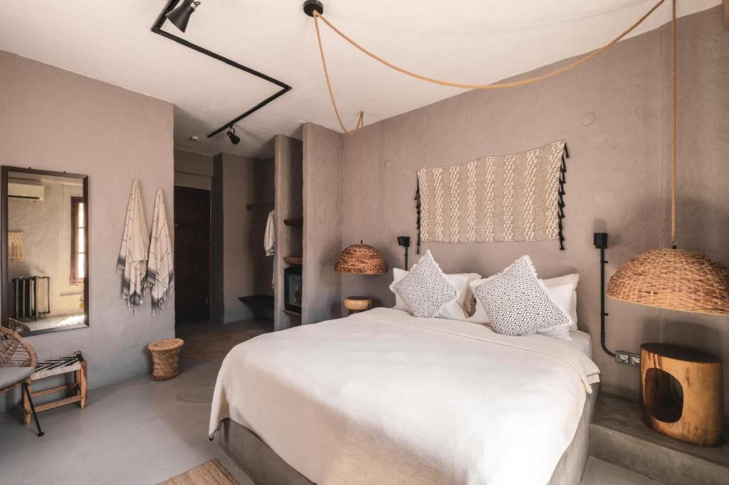 a bedroom with a large white bed with pillows at GAIA ALAÇATI in Alaçatı