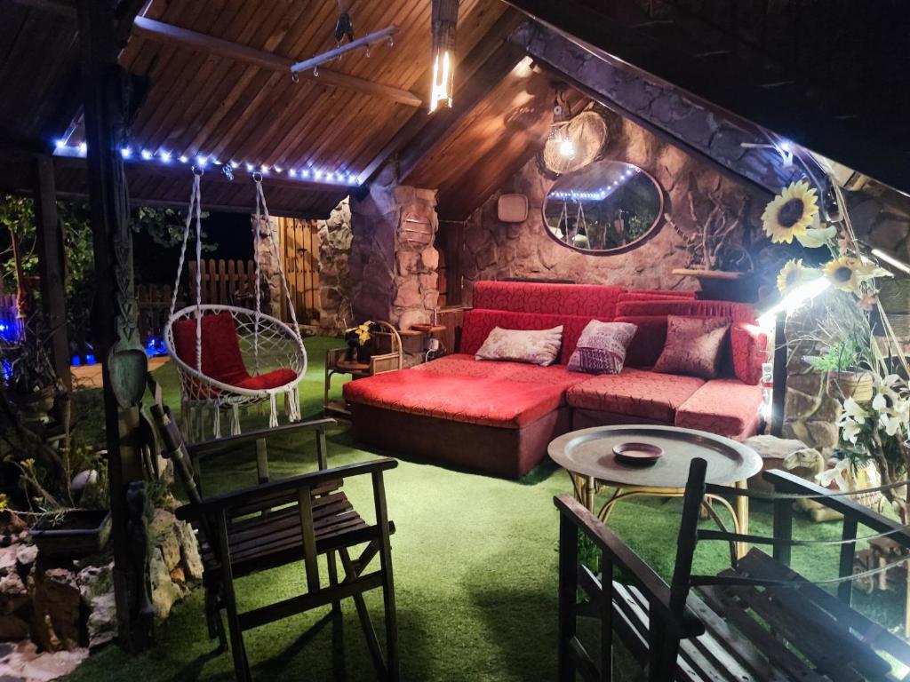Una sala de estar con un sofá rojo y una mesa. en Viviendas Uso Turisitico, Al BUHAR, en Torrejón del Rey