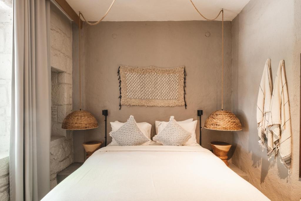 a bedroom with a bed with two lamps at GAIA ALAÇATI in Alaçatı
