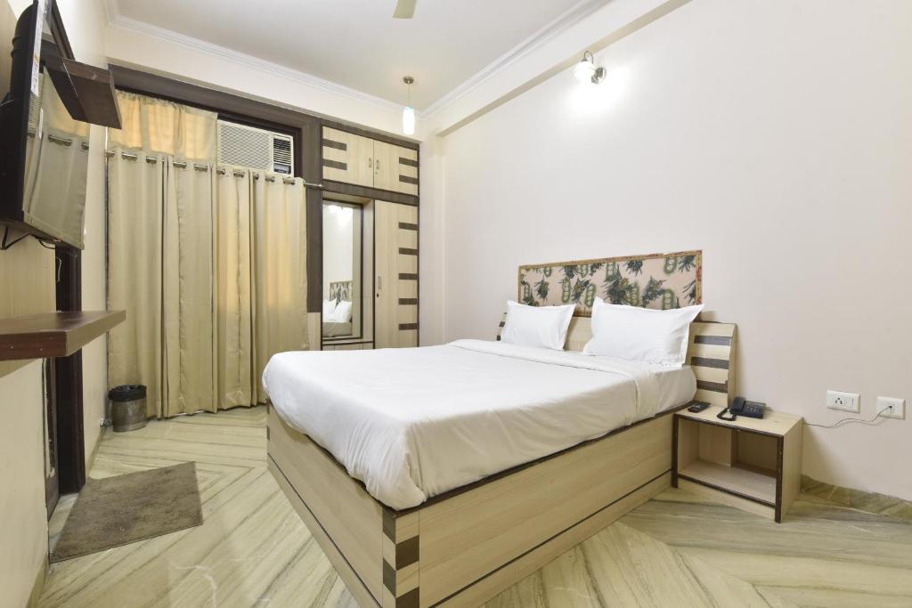 a bedroom with a bed and a television in it at Hotel The Grand Kailash in Jaipur
