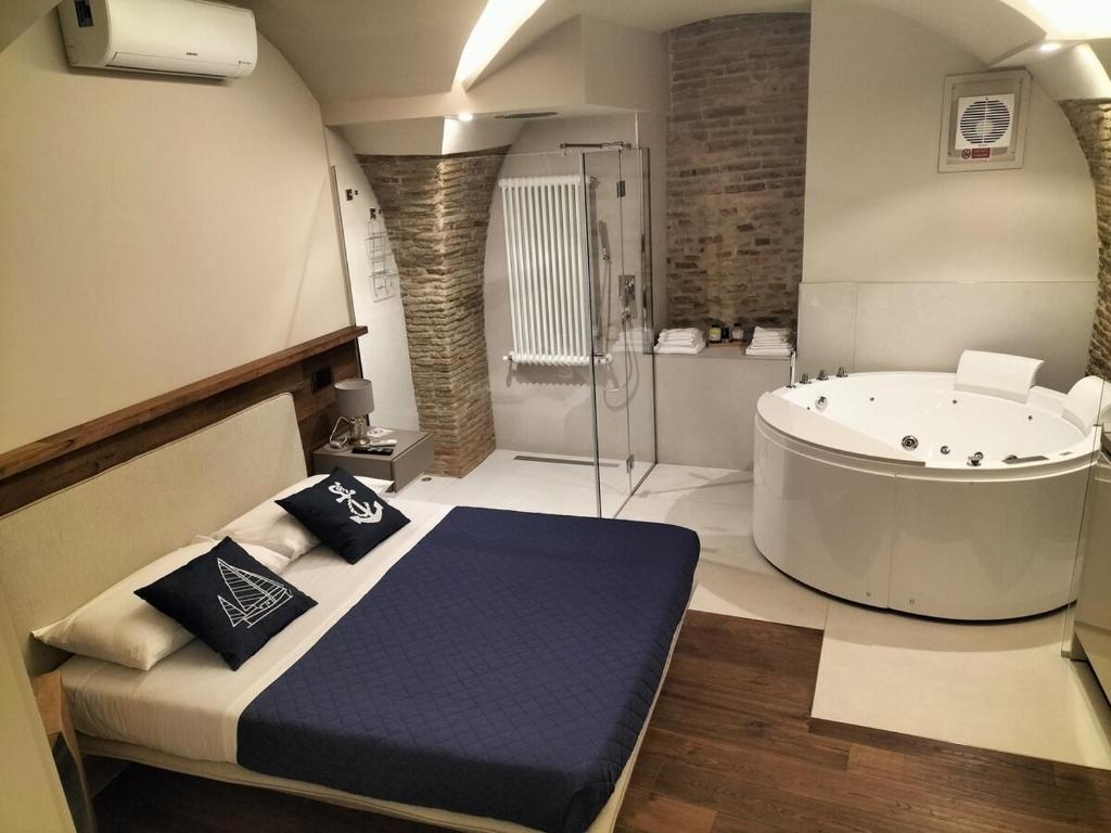 een grote badkamer met een bad en een bed. bij Via Montecastello Emotional Room in Termoli