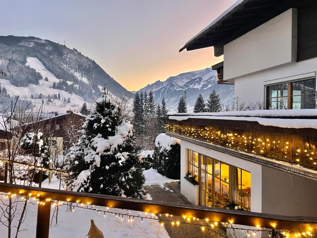 a building with christmas lights in the snow at Landhaus Bergner Alm in Bruck an der Großglocknerstraße