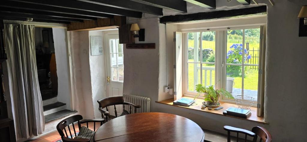 a dining room with a table and chairs and a window at Nature cottage in Snowdonia National Park in Beddgelert
