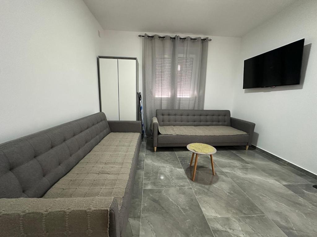 a living room with two couches and a table at Apartman 2 in Šušanj