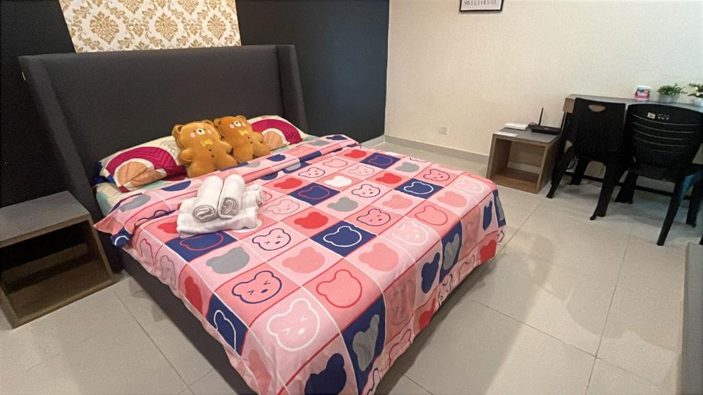 een bed met een teddybeer bovenop bij Yenbear Homestay Kozi Square Kuching Sarawak in Kuching