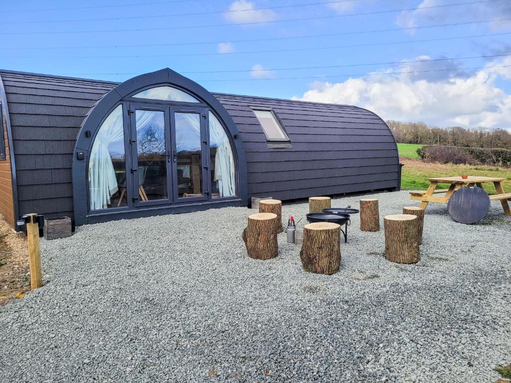 a building with a bunch of logs in front of it at Lakeview Lodge- Uk40692 in Crowhurst