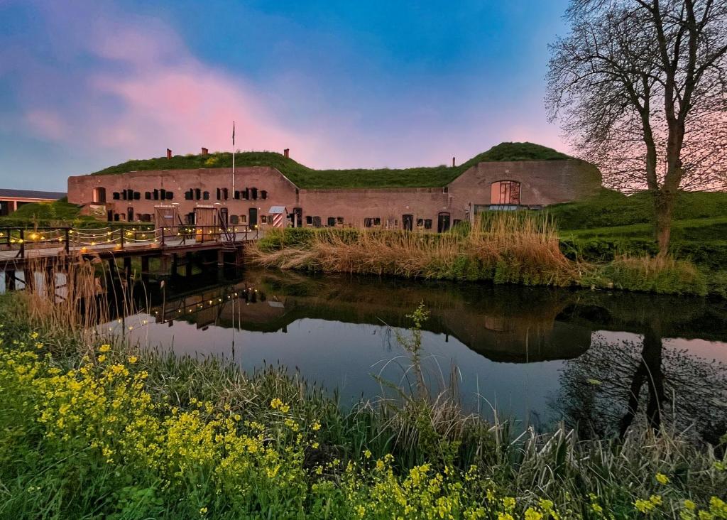 un antiguo edificio junto a un cuerpo de agua en Bed & Breakfast Fort Bakkerskil, en Nieuwendijk