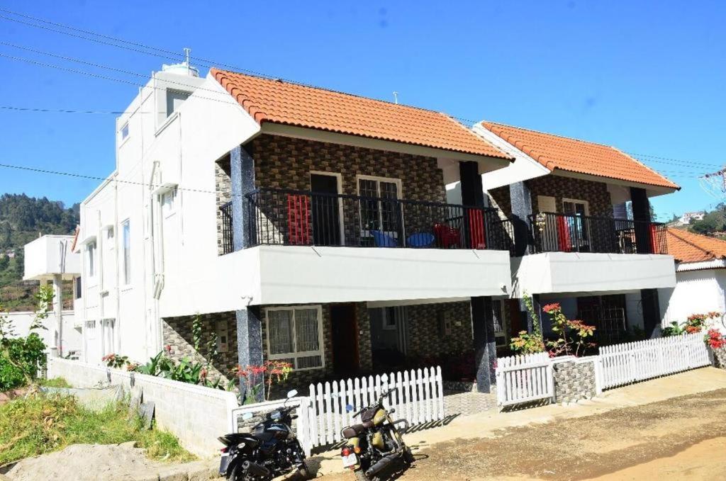 two motorcycles parked in front of a house at Cheerful Chalet in Kodaikānāl