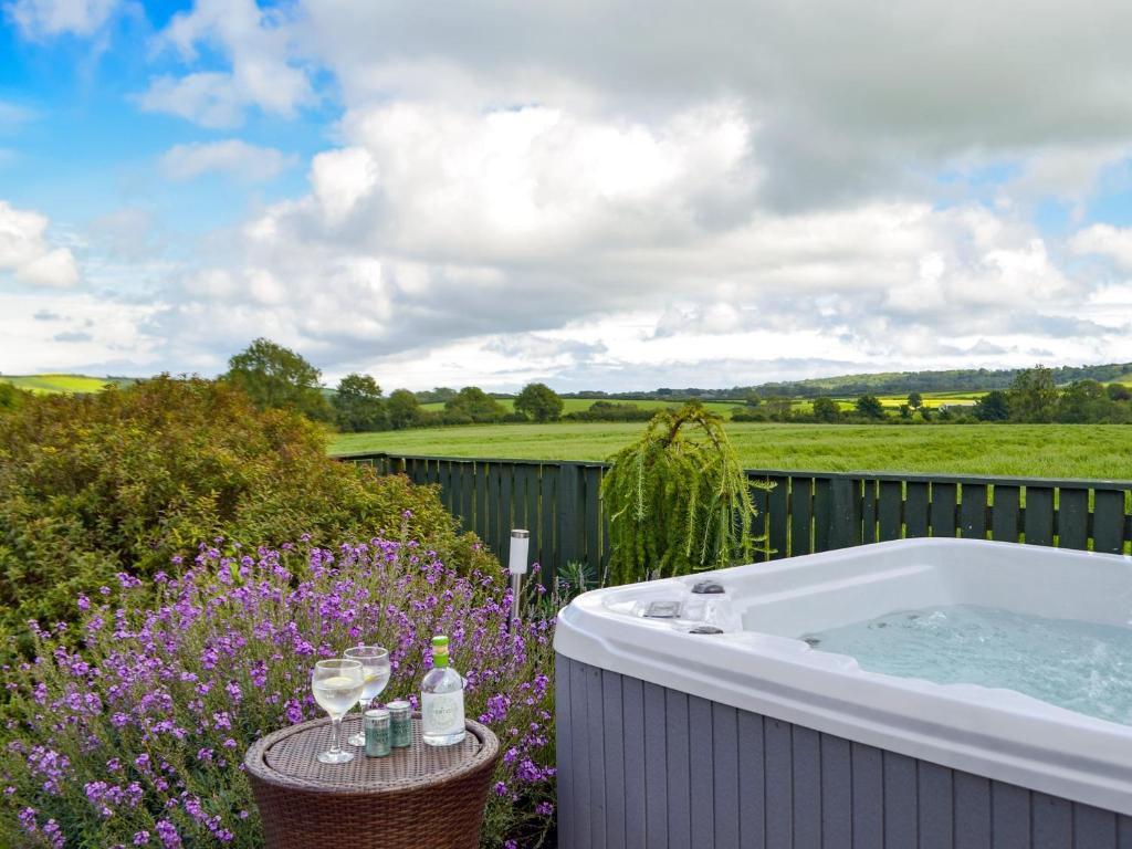 a bath tub in a garden with purple flowers at Pleasant Valley in New Hedges