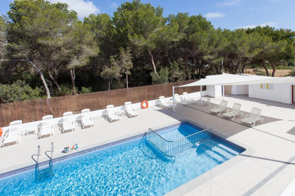una piscina con sedie a sdraio e un piscina con piscina di Typic Art a Es Cana