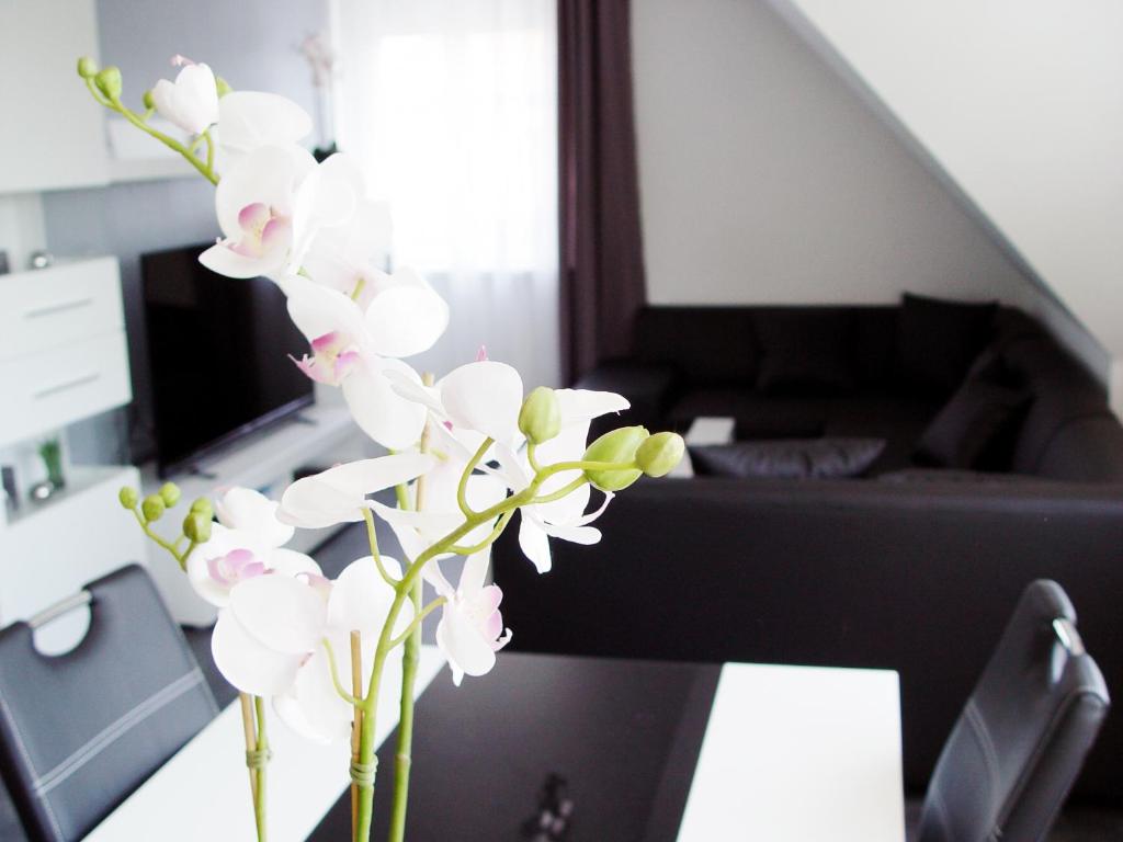 a vase of white flowers sitting on a table at La Domus Premium Osnabrück Lotte in Lotte