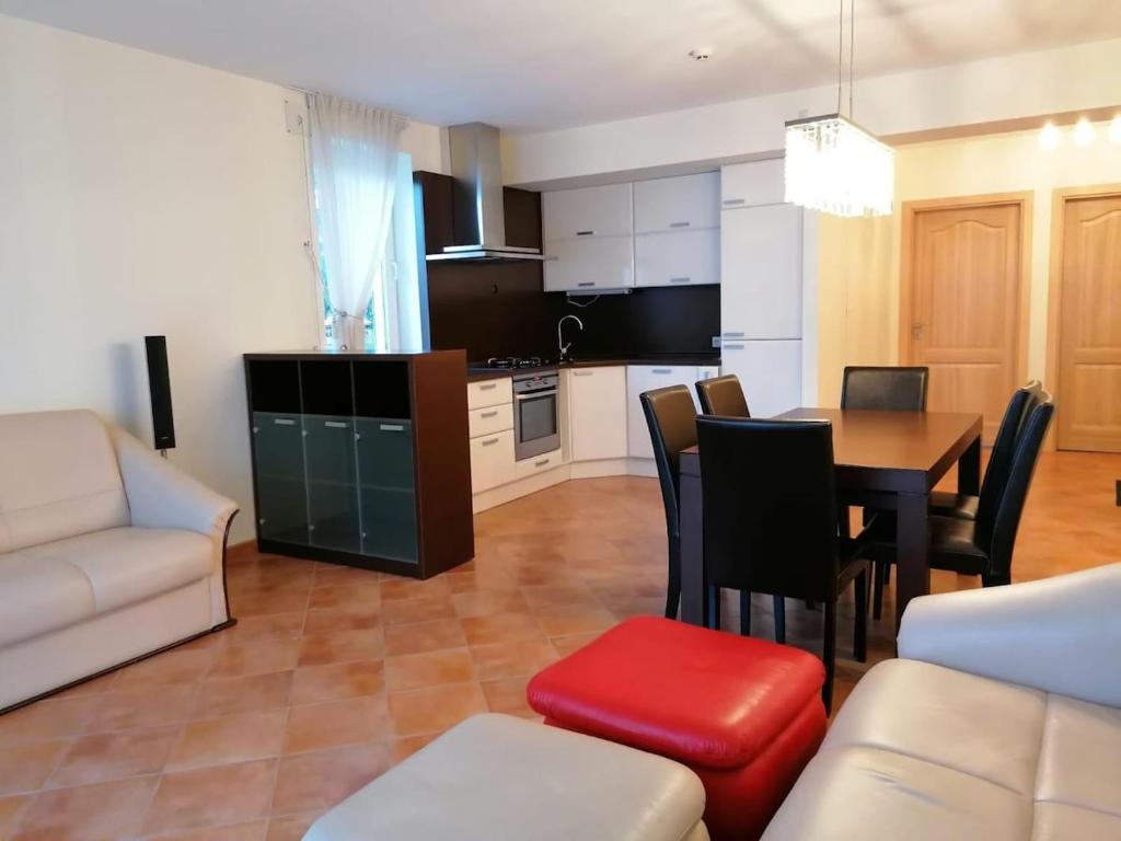 Una cocina y una sala de estar con una mesa y un sofá. en Vytautas Apartments, en Šiauliai