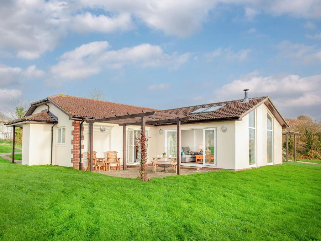 a white house with a lawn in front of it at Wonkey Donkey Cottage in Seaton
