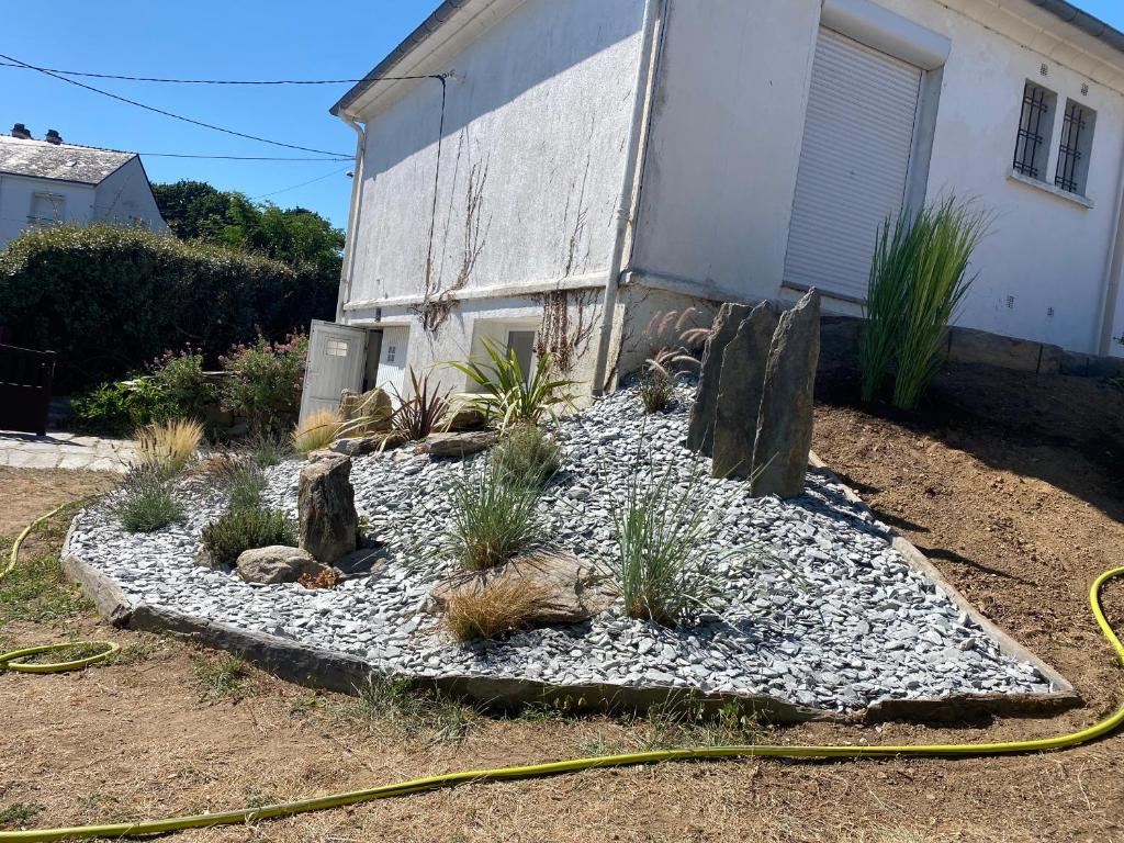 a garden with rocks and plants in front of a house at Maison spacieuse et agréable à 200m de la mer in Saint-Nazaire