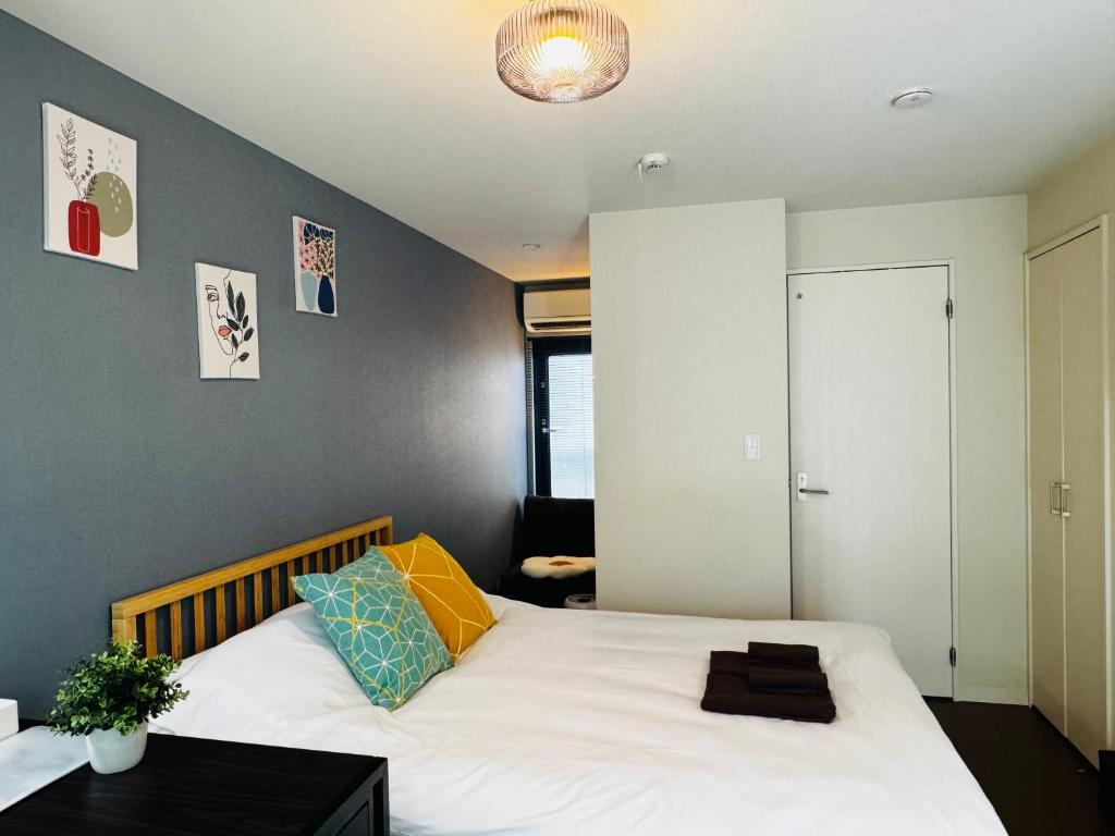 a bedroom with a large white bed with a black table at Lucky you! YOTSUYA in Tokyo