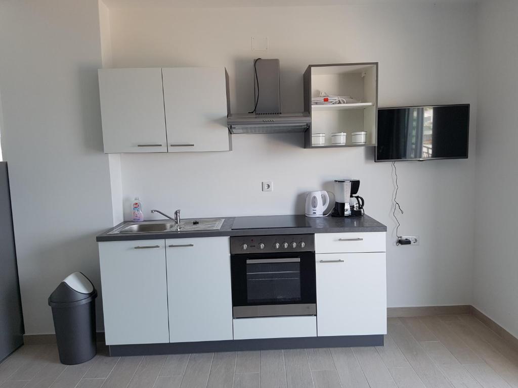 a kitchen with white cabinets and a black oven at Apartments Tereza in Senj