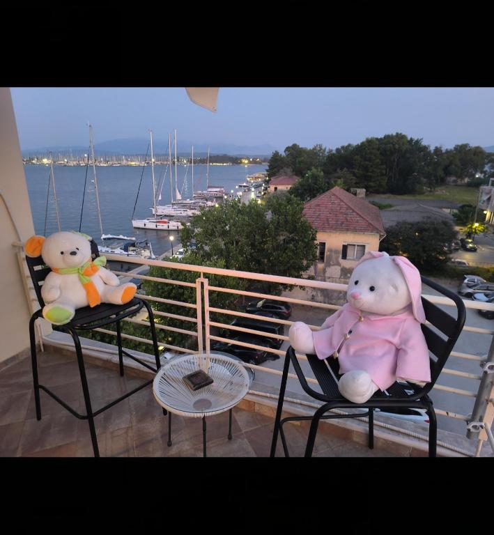 dwa pluszowe misie siedzące na krzesłach na balkonie w obiekcie AB Preveza Apartments -15 Meters Over the Sea w Prewezie