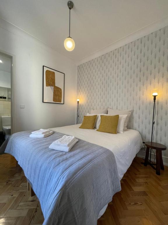 a bedroom with a large bed with two towels on it at Suites Vintage in Lisbon