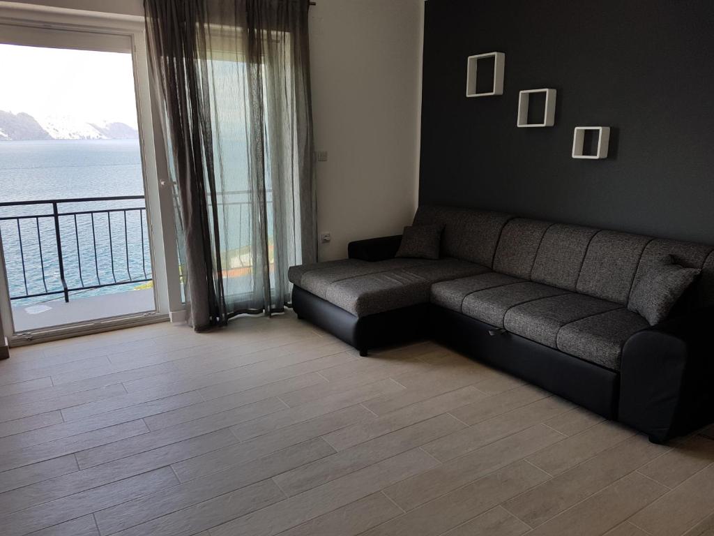 a living room with a couch and a large window at Apartments Tereza in Senj