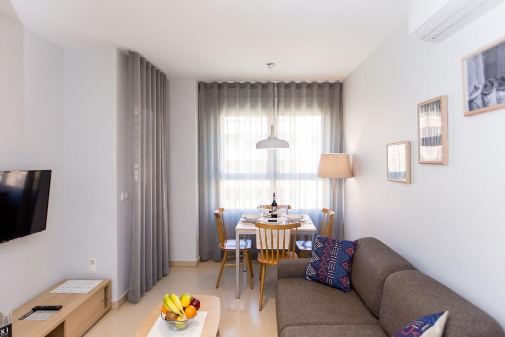 ein Wohnzimmer mit einem Sofa und einem Tisch in der Unterkunft Valenciaflats Ciudad de las Ciencias in Valencia