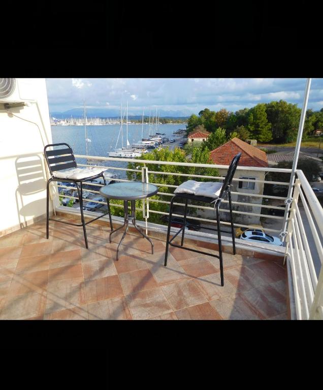 balkon ze stołem i krzesłami oraz widokiem na wodę w obiekcie AB Preveza Apartments -15 Meters Over the Sea w Prewezie