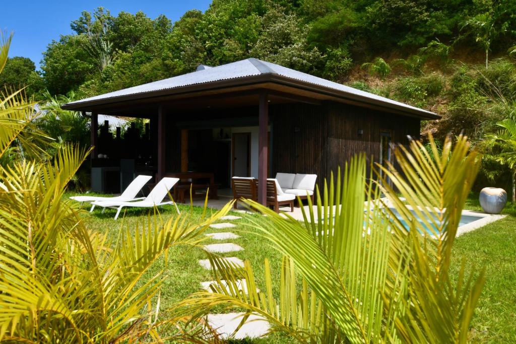 a cabin with two chairs and a table and chairs at Les Hauteurs de Citronnelles in Case-Pilote