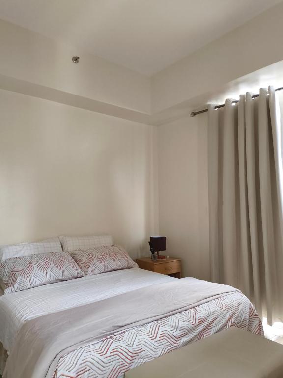 ein Schlafzimmer mit großem Bett und Fenster in der Unterkunft Saint honore megaworld business park Iloilo City in Iloilo City