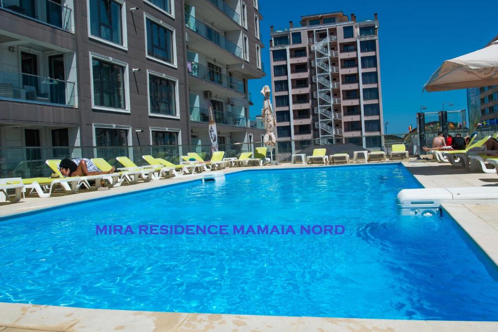 a large blue swimming pool with chairs and condos at MIRA RESIDENCE Apart & Penthouse in Mamaia Sat/Năvodari
