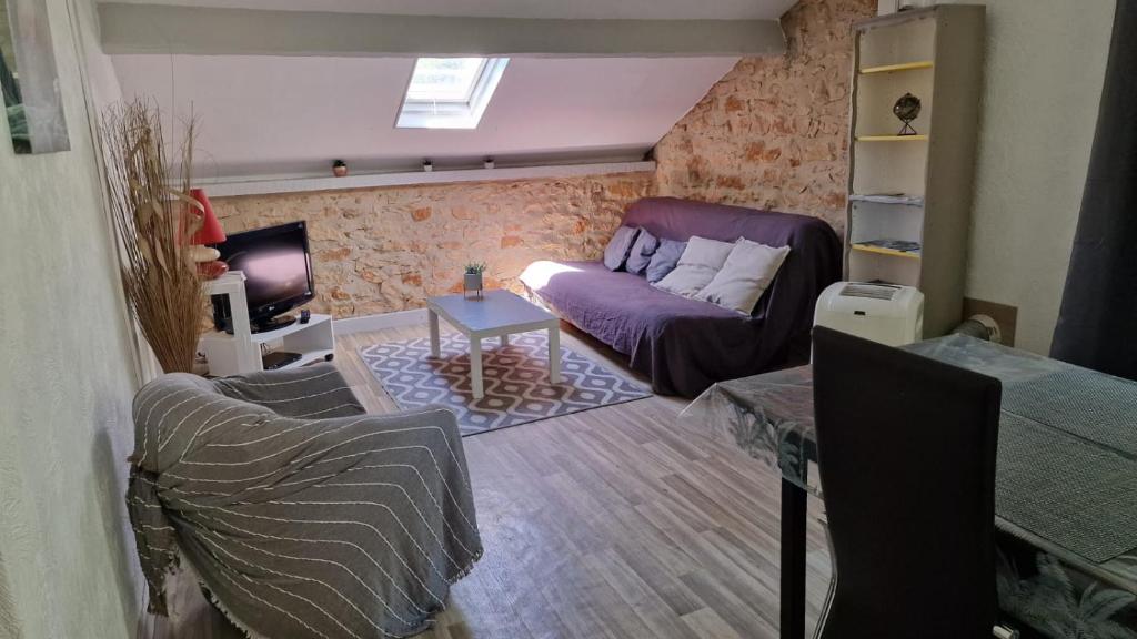 un salon avec un canapé et une table dans l'établissement Appartement à 1km de Sarlat à la campagne, à Sarlat-la-Canéda