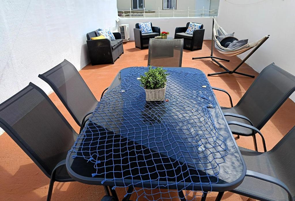 a blue table with a potted plant on top of it at Casa Ibaía, típica e acolhedora no centro de Olhão in Olhão