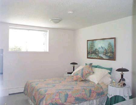 een slaapkamer met een bed en een raam bij Island View B&B in Nanaimo