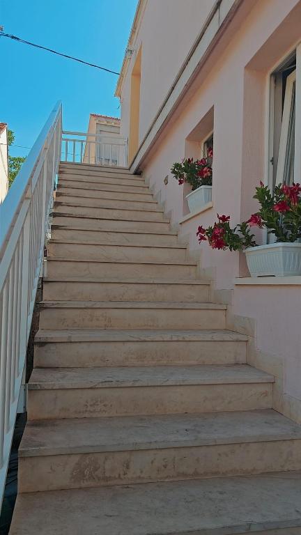 a staircase leading up to a building with flowers at Mikulin Apartments in Lumbarda