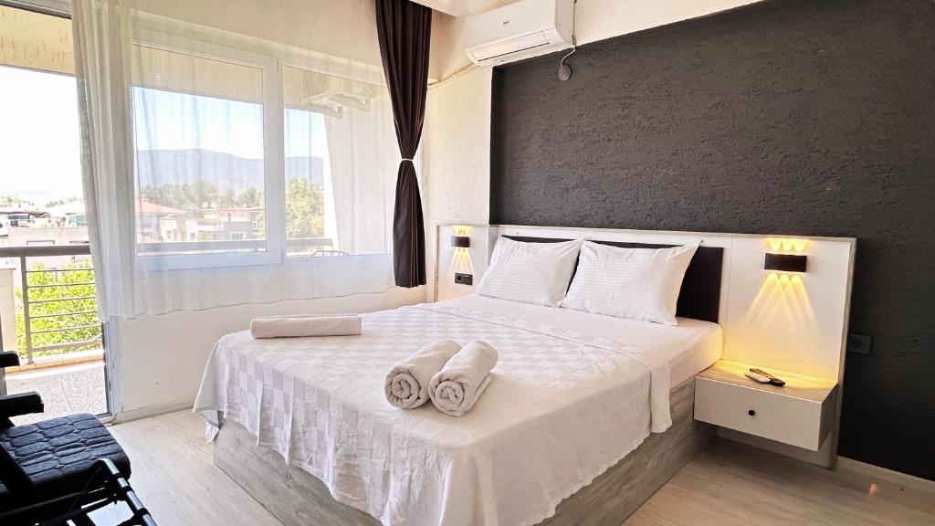 a bedroom with a white bed with towels on it at Ephesus Nobel Otel in Selcuk