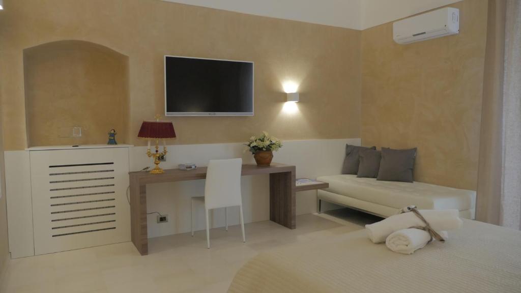 Habitación con cama, escritorio y TV. en Borgo Marsala, en Trani