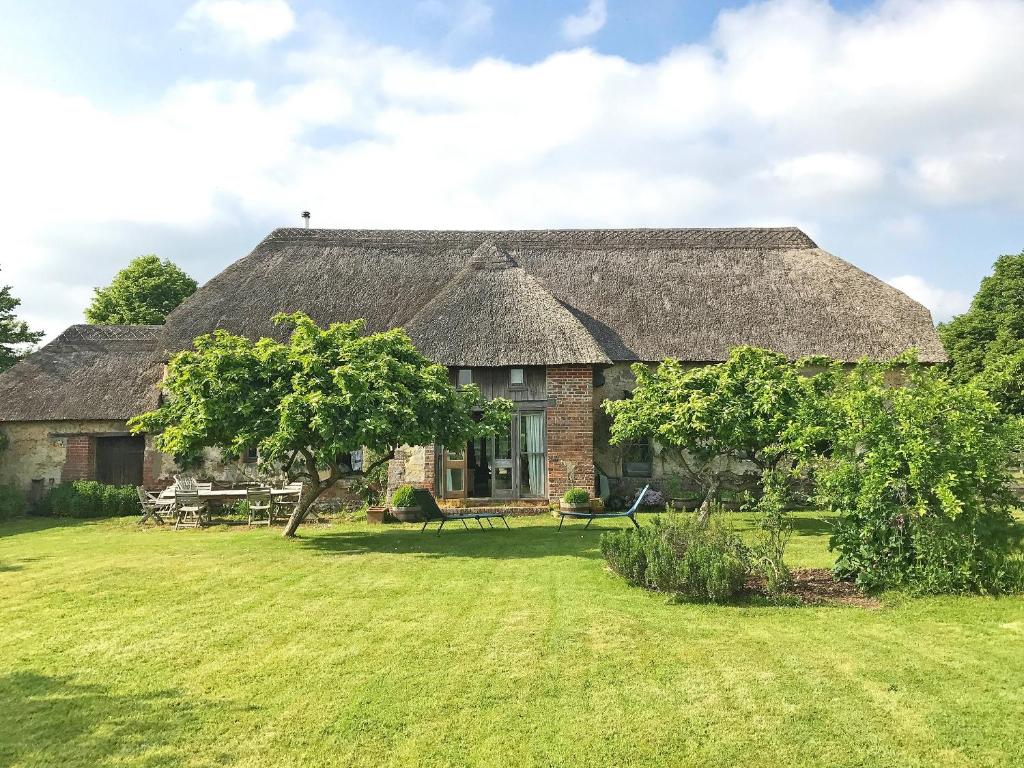 an old stone house with a grass roof at North Barn in Tolpuddle