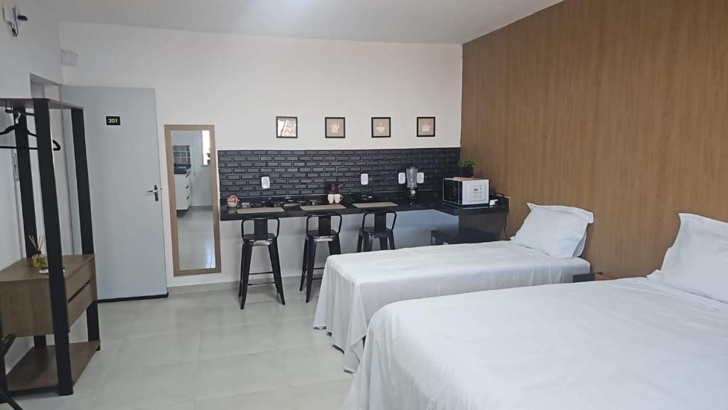 a hotel room with two beds and a counter at Nobre Flats 201 in Petrolina