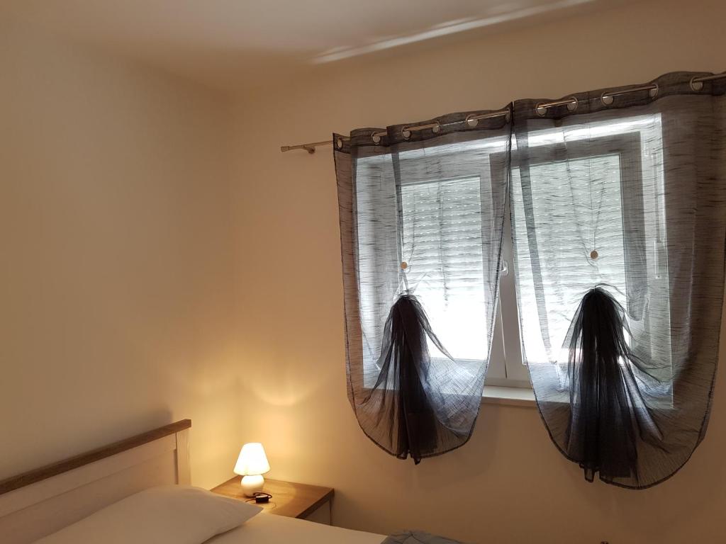 a bedroom with a window with curtains and a bed at Apartments Tereza in Senj