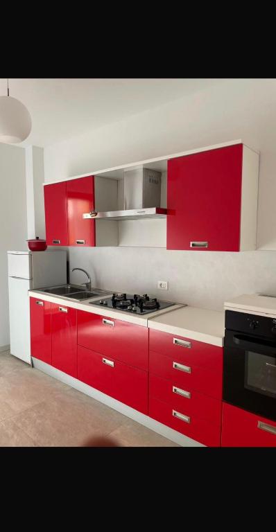 a kitchen with red cabinets and a stove in it at Mamma Gina in Vieste