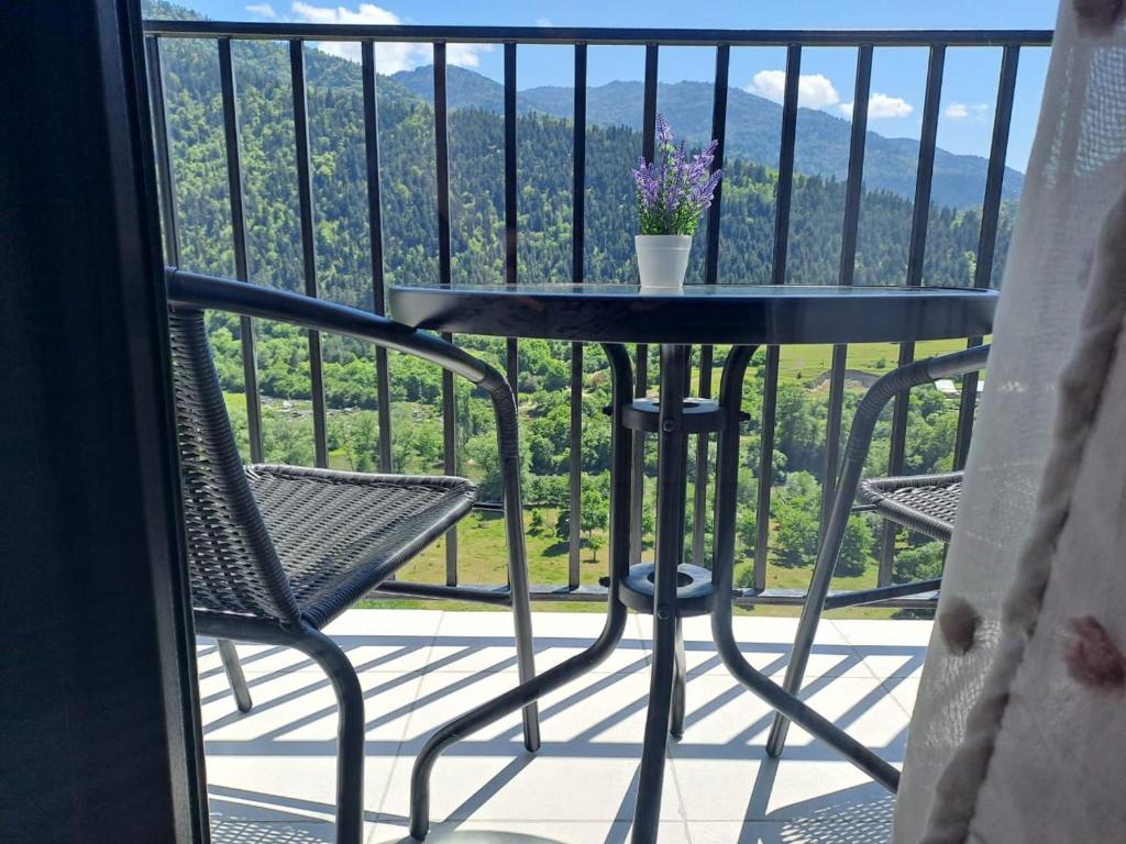 a table and chairs on a balcony with a view at Mountains Inspiration Apartments in Likani