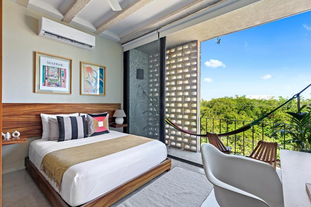 a bedroom with a bed and a balcony at Hola Donceles Suites in Cancún