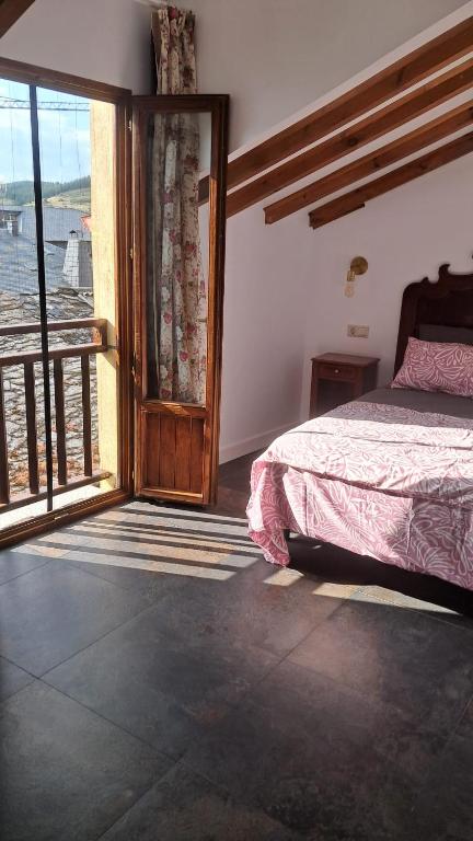 a bedroom with a bed and a large window at Casa Loma Manolo in Molinaseca