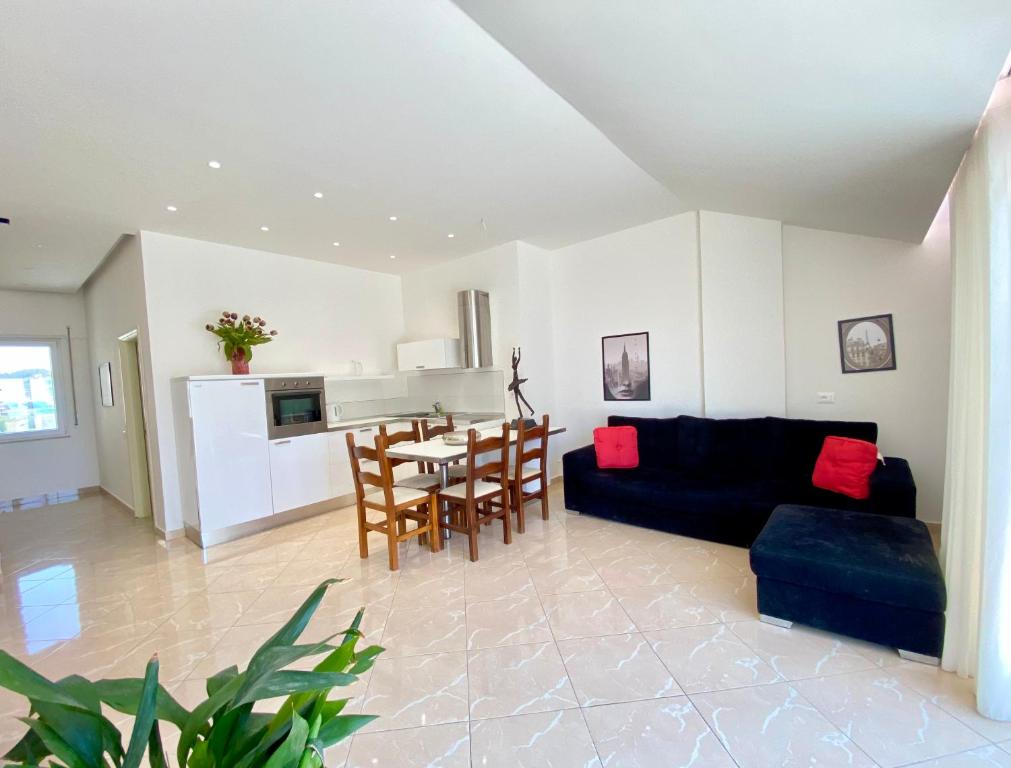 a living room with a black couch and a table at Lovely Rooftop Apartment in Golem