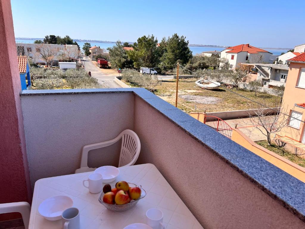 a bowl of fruit on a table on a balcony at Apartmani Dorana in Vrsi